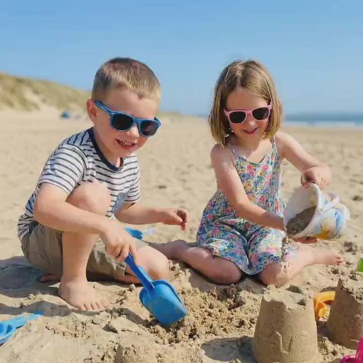 Boy and girl playing in the sand protected by BioSunnies